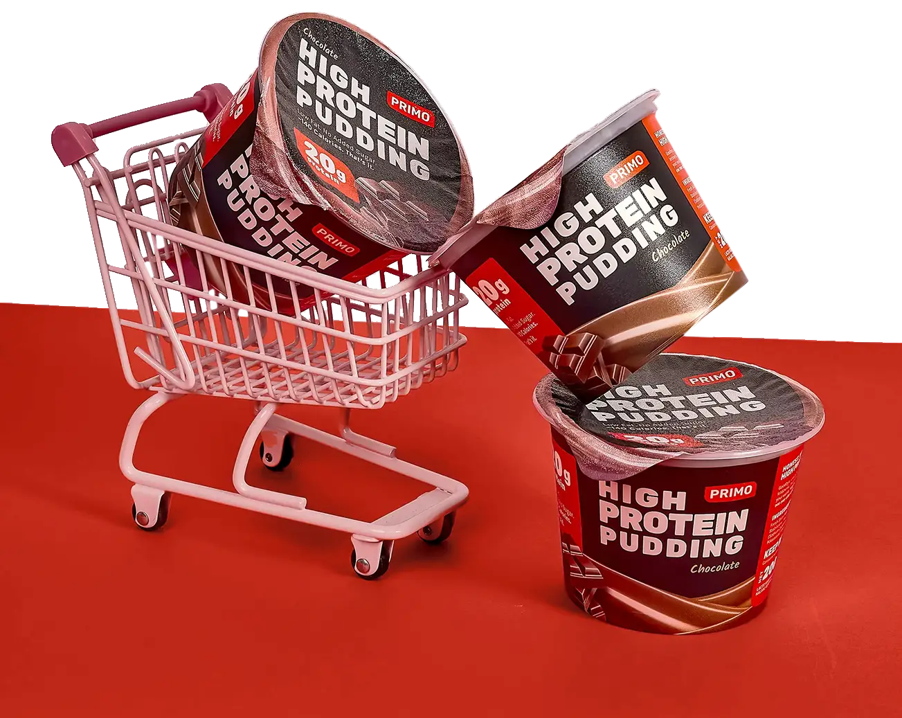 Cutout image of three Primo Chocolate High Protein Pudding cups in a playful mini shopping cart on a red surface.